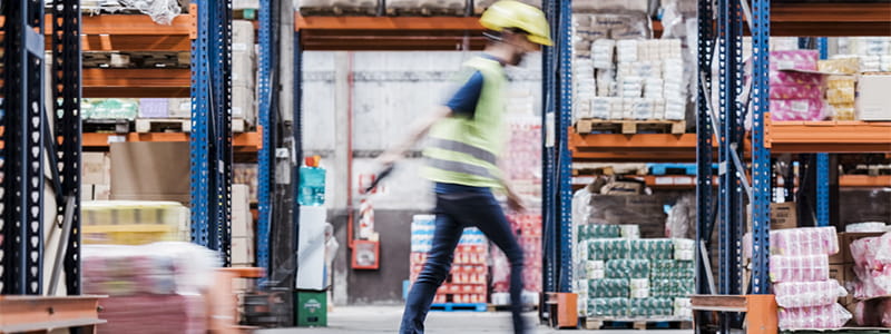 Man pulling trolley in warehouse