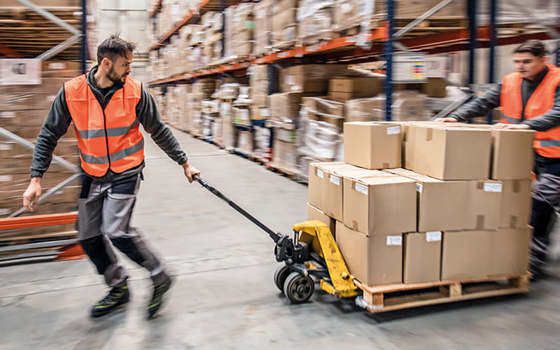 Two men with pallet of goods in warehouse