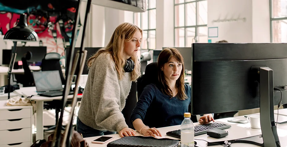 Two women in office looking at computer screen